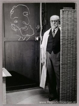 Henri Matisse staat tegen een scherm en tekent met krijt